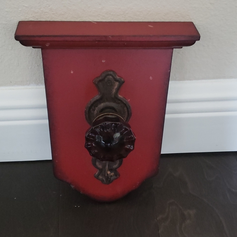 Red wall hanging includes a knob and hook